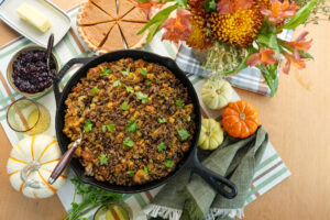 Castiron skillet with cornbread stuffing at a holiday table.