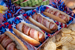 Bacon-Wrapped Hempler's hot dogs in a 4th of July setting